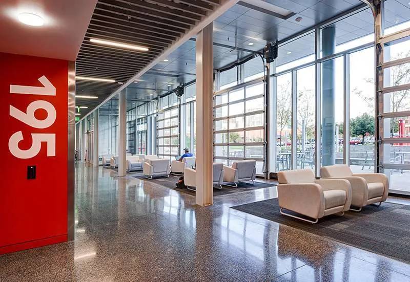 Ground-floor lounge of the AES building, with glass roll-up doors open to campus.